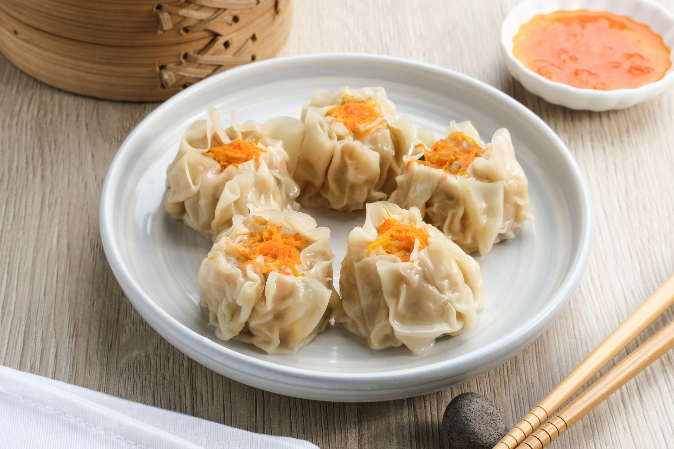 Delicious Dim Sum, home made chinese dumplings served on plate, with sauce and chopstick